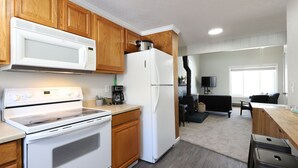 Una cocina moderna con armarios de madera, una estufa blanca y un refrigerador.