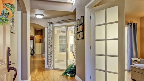 A hallway with wooden flooring, a door with frosted glass panels, and a decorative plant. - Dog Friendly Cozy Quiet Eagle ID Home sleeps 6 (Eagle)