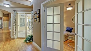 A hallway with wooden flooring, a glass door leading to a patio, and a seating area with a round table. - Dog Friendly Cozy Quiet Eagle ID Home sleeps 6 (Eagle)