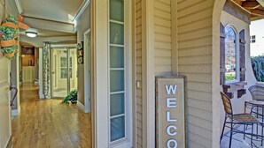 A wooden exterior with a 'WELCOME' sign, a covered patio with chairs, and a hallway leading to a door. - Dog Friendly Cozy Quiet Eagle ID Home sleeps 6 (Eagle)