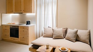 A compact bedroom with a bed, bedside table, and a kitchenette area with a stove and cabinets. - ERAMAI  (Patras)
