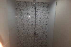 Deluxe tweepersoonskamer | Badkamer | Een douche, handdoeken, zeep