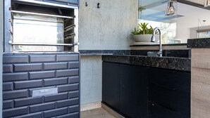 A modern kitchen with a black countertop, a built-in oven, and a potted plant on the counter.
