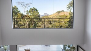 A spacious living room with a large window overlooking a pool and garden.