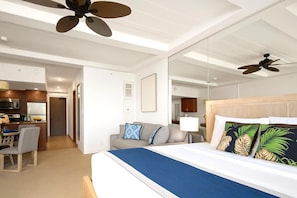Een hotelkamer met een bed, een slaapbank, een eethoek en een keuken.