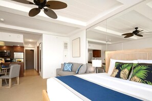 Ein Hotelzimmer mit Bett, Sofa, Essbereich und einer Küche.