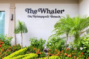 Une enseigne indiquant « The Whaler On Ka'anapali Beach », avec un jardin luxuriant devant.