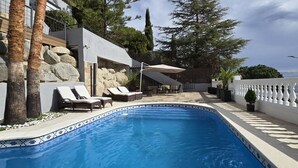 A swimming pool with lounge chairs, a covered seating area, and a view of the sea. - Opening Doors Premià Dalt Amazing views with pool (Premià de Dalt)