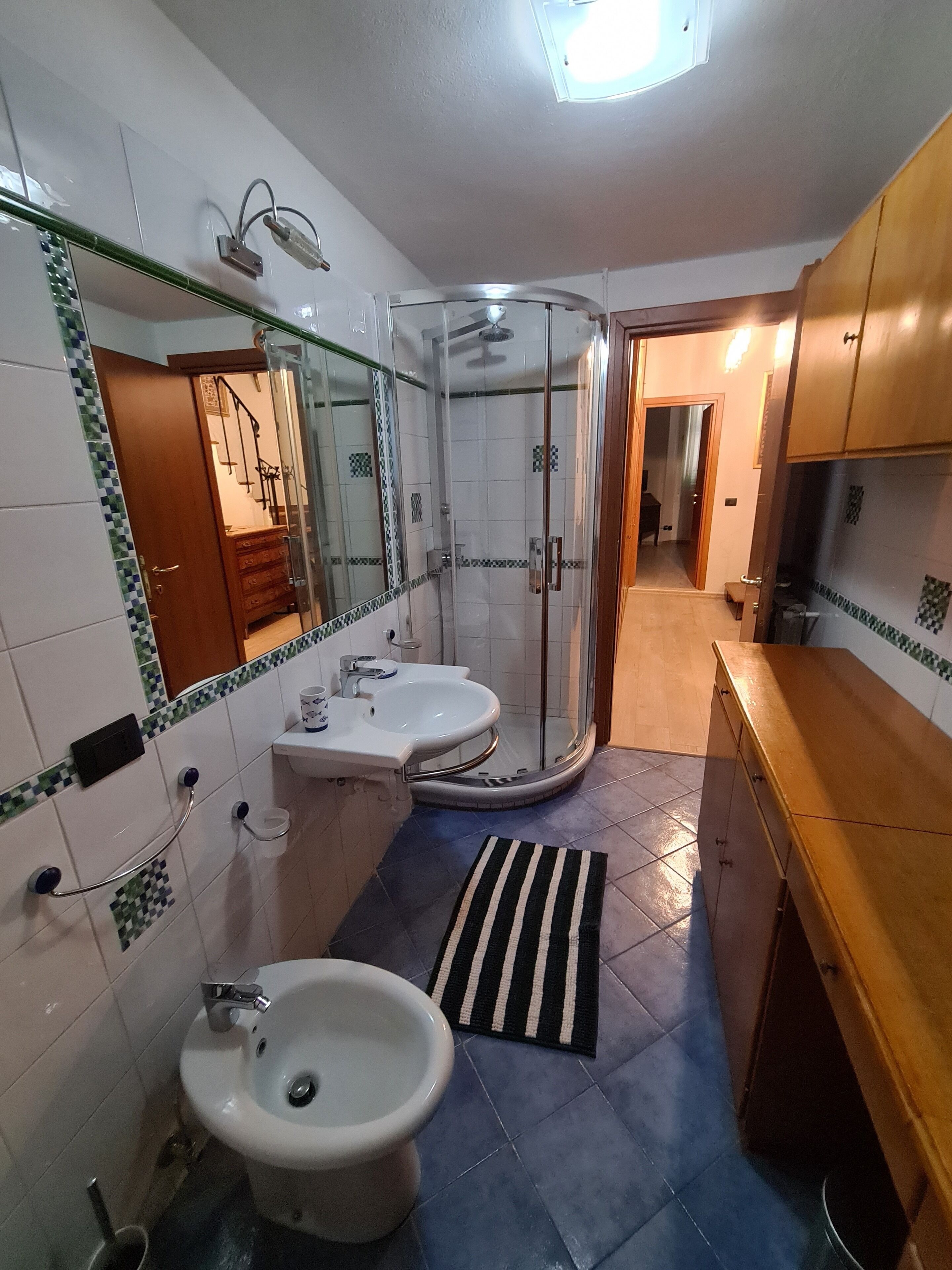 Et badeværelse med brusebad, vask og toilet.