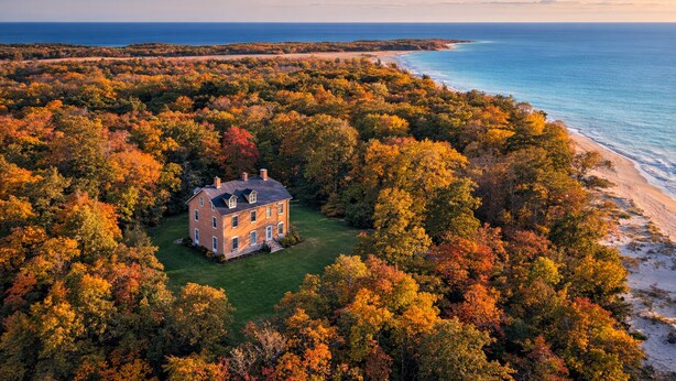 A large house surrounded by dense forest with a beach and ocean in the background. - Furness Mansion (Chesterton)