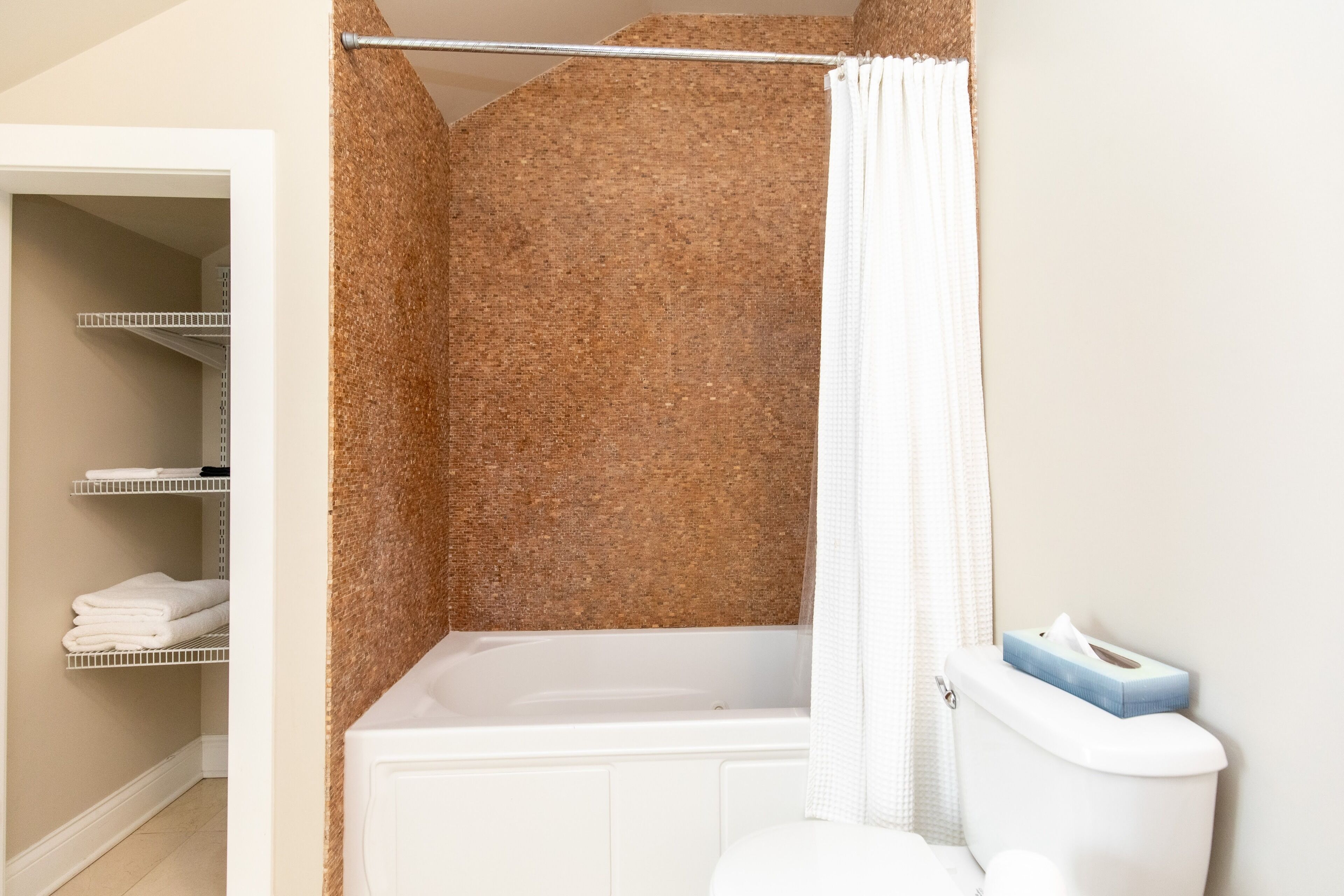 A bathroom with a bathtub, a toilet, and a shower curtain.