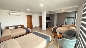 A hotel room with two beds, a sofa, a small table, and a TV. - HOTEL CAMELINAS EXPRESS (Lazaro Cardenas)