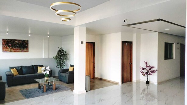 A spacious living area with a sofa, coffee table, and potted plants. - HOTEL CAMELINAS EXPRESS (Lazaro Cardenas)