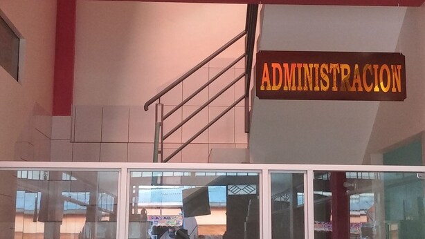 A multi-level building with a glass entrance, potted plants, and a sign that reads "ADMINISTRACION". - HOSTAL ETERNA PRIMAVERA  (Copacabana)