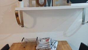 Et træbord med magasiner og brochurer, en potteplante og en hylde med ordet "LOVE" og en sort gaffeldekoration.