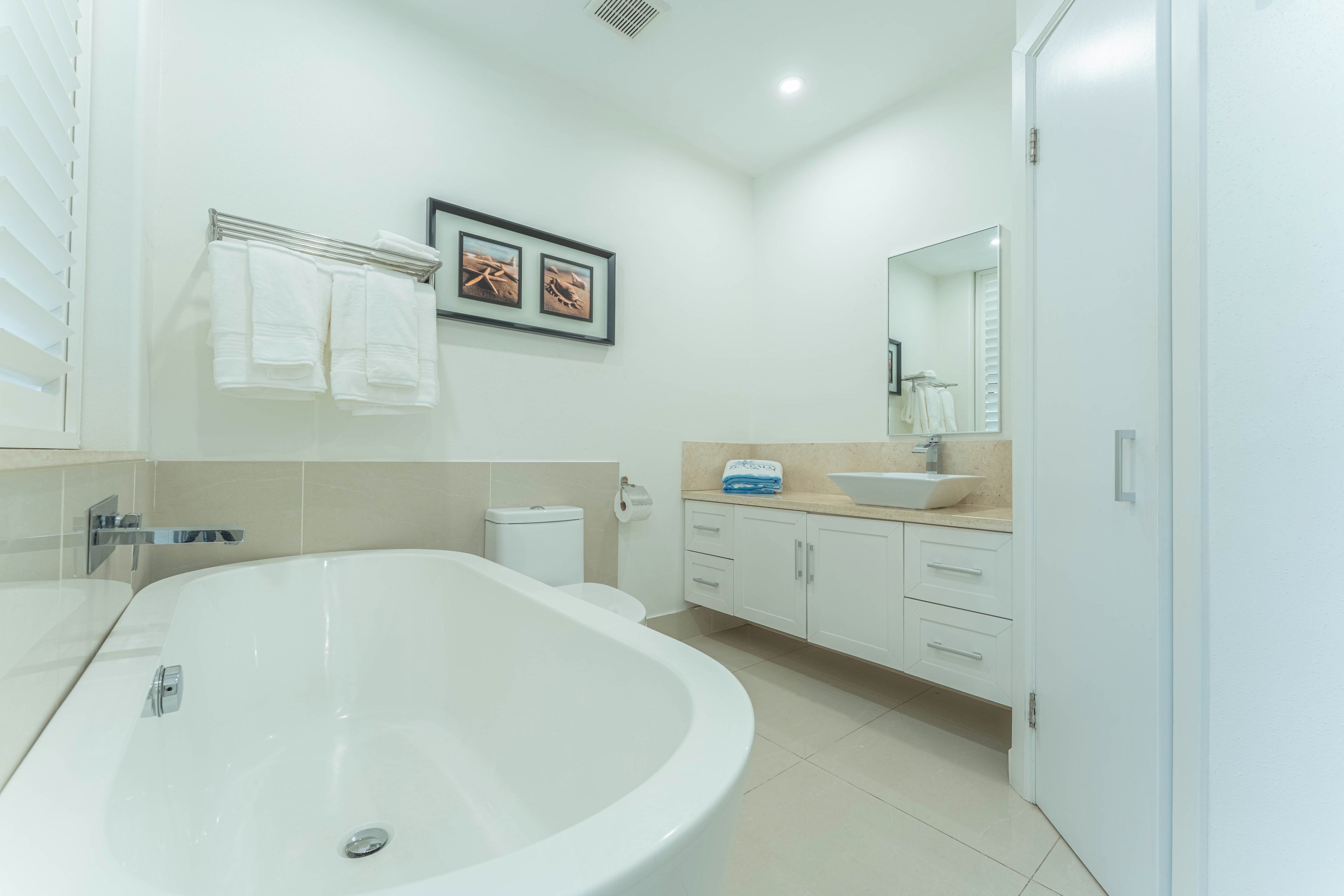 A modern bathroom with a freestanding bathtub, a vanity with a sink, and a toilet.