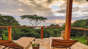 A terrace with a view of the sunset, wooden furniture, and a bottle of champagne. - Vista Sirena: Expansive Ocean View 4 bedroom / 4.5 bath home above Dominical (Puntarenas Province)