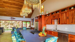A spacious kitchen with a long island, wooden cabinets, and a stone wall backdrop. - Vista Sirena: Expansive Ocean View 4 bedroom / 4.5 bath home above Dominical (Puntarenas Province)