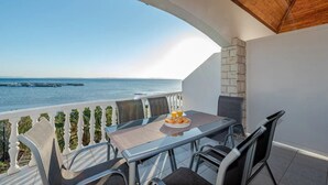 Un balcón con una mesa dispuesta para el desayuno, con vista a un cuerpo de agua.