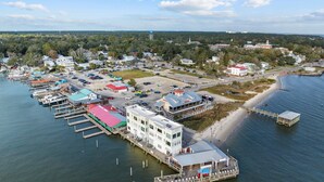 An aerial view of a coastal town with a marina, waterfront buildings, and a beach.