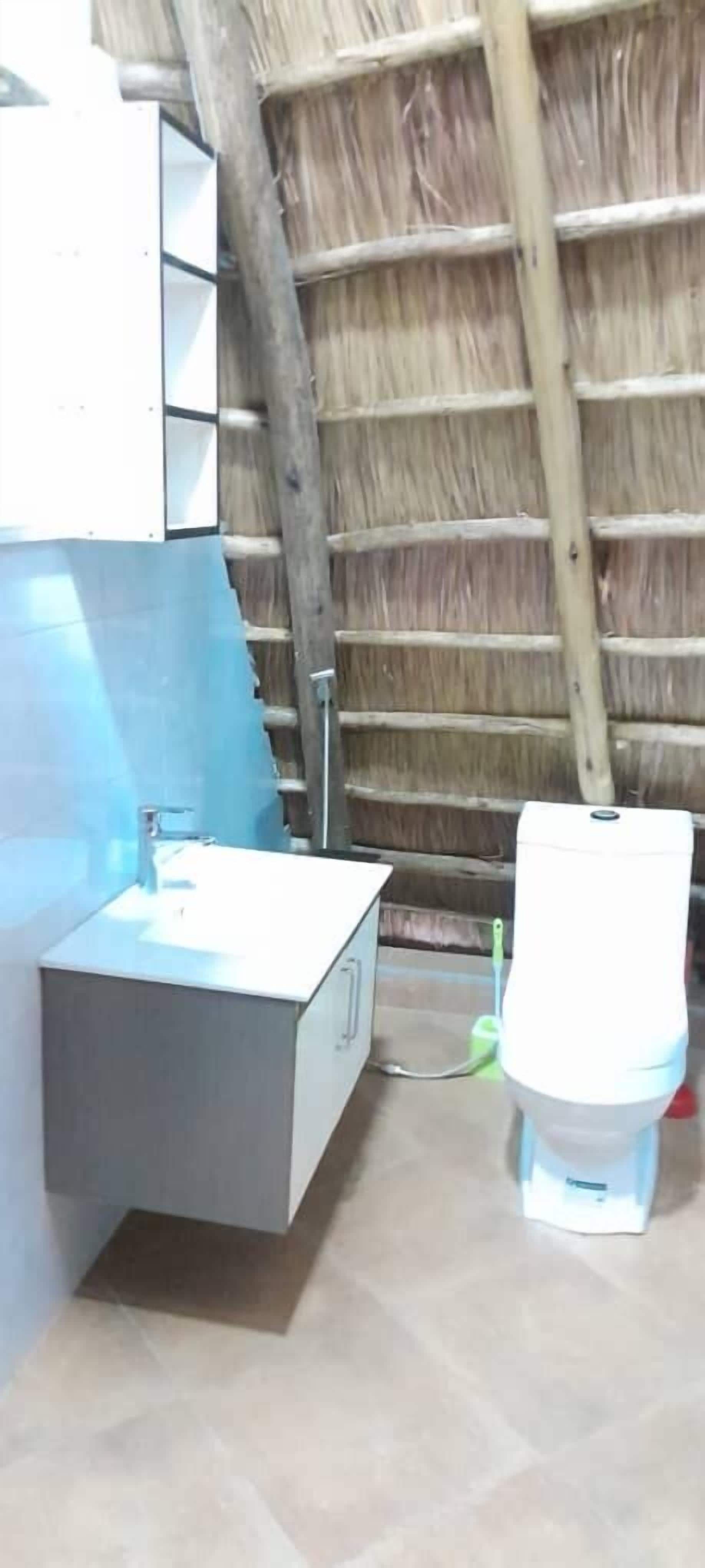 Ein Badezimmer mit einem modernen Waschbecken, einer Toilette und einer Holzbodenverkleidung.