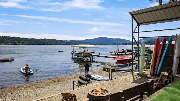 A lakeside setting with a dock, paddle boats, and canoes.