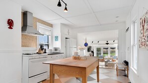A modern kitchen with white appliances, a wooden table, and a checkered floor.