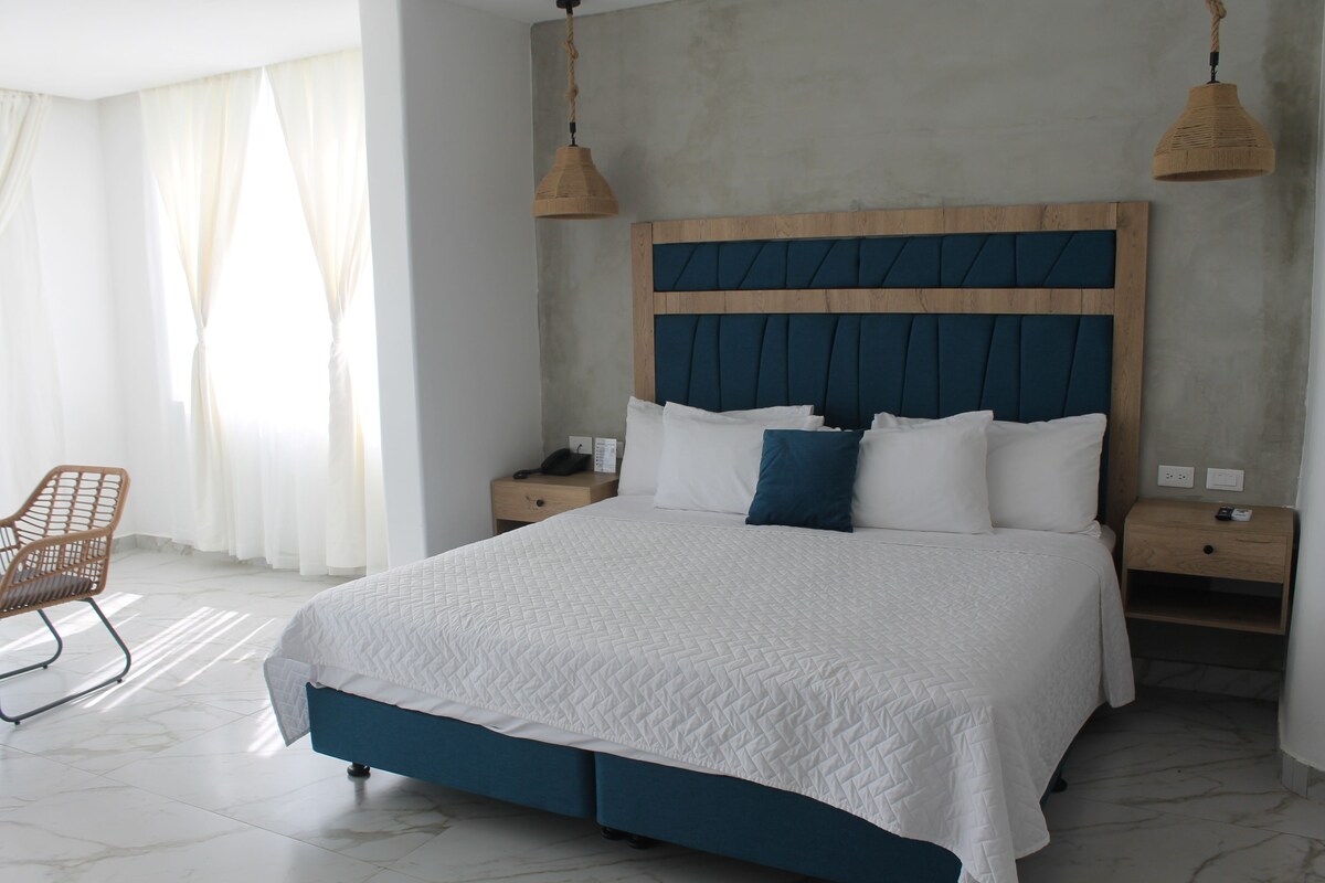 A modern bedroom with a large bed, wooden headboard, and two bedside tables.