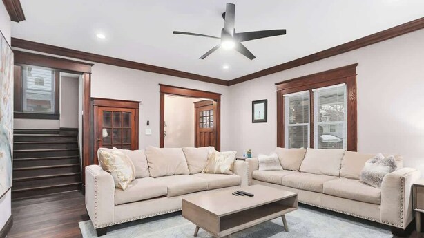 A living room with a sectional sofa, a coffee table, and a ceiling fan.