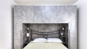 Une chambre à coucher avec un lit, une tête de lit et des étagères intégrées.