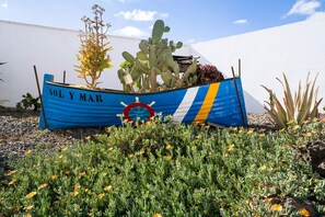 Une enseigne avec l’inscription « SOL Y MAR », un dessin représentant un volant, ainsi que des cactus et des plantes succulentes.