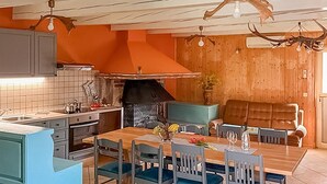 Un comedor con mesa de madera, sillas y un sofá.
