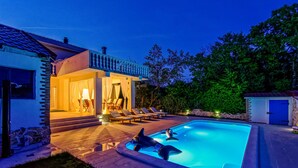 A swimming pool with lounge chairs and a covered area with a table and chairs. - Gorgeous home in Gornji Muc (Gornji Muc)