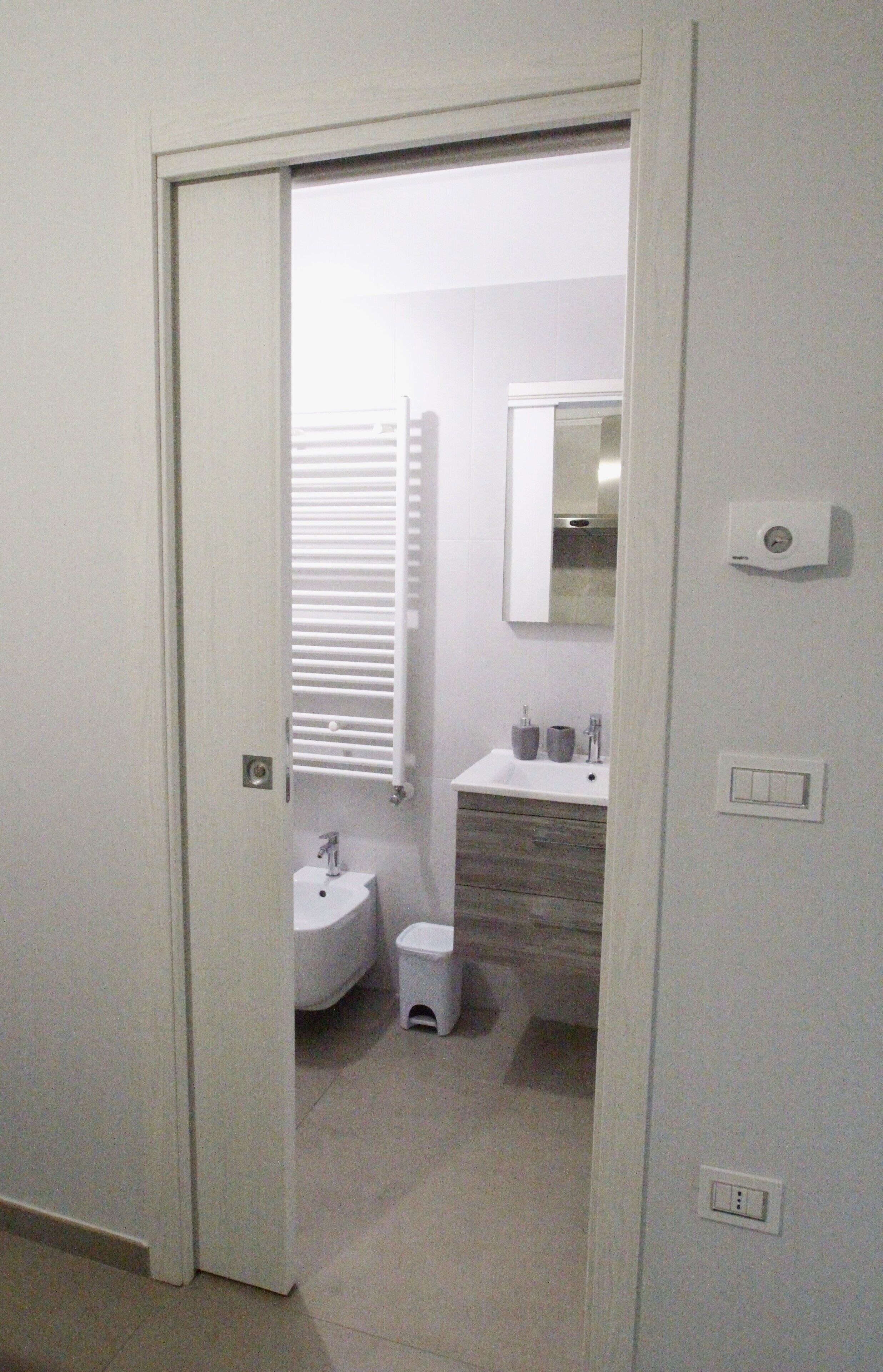Un baño con inodoro, lavamanos y espejo.