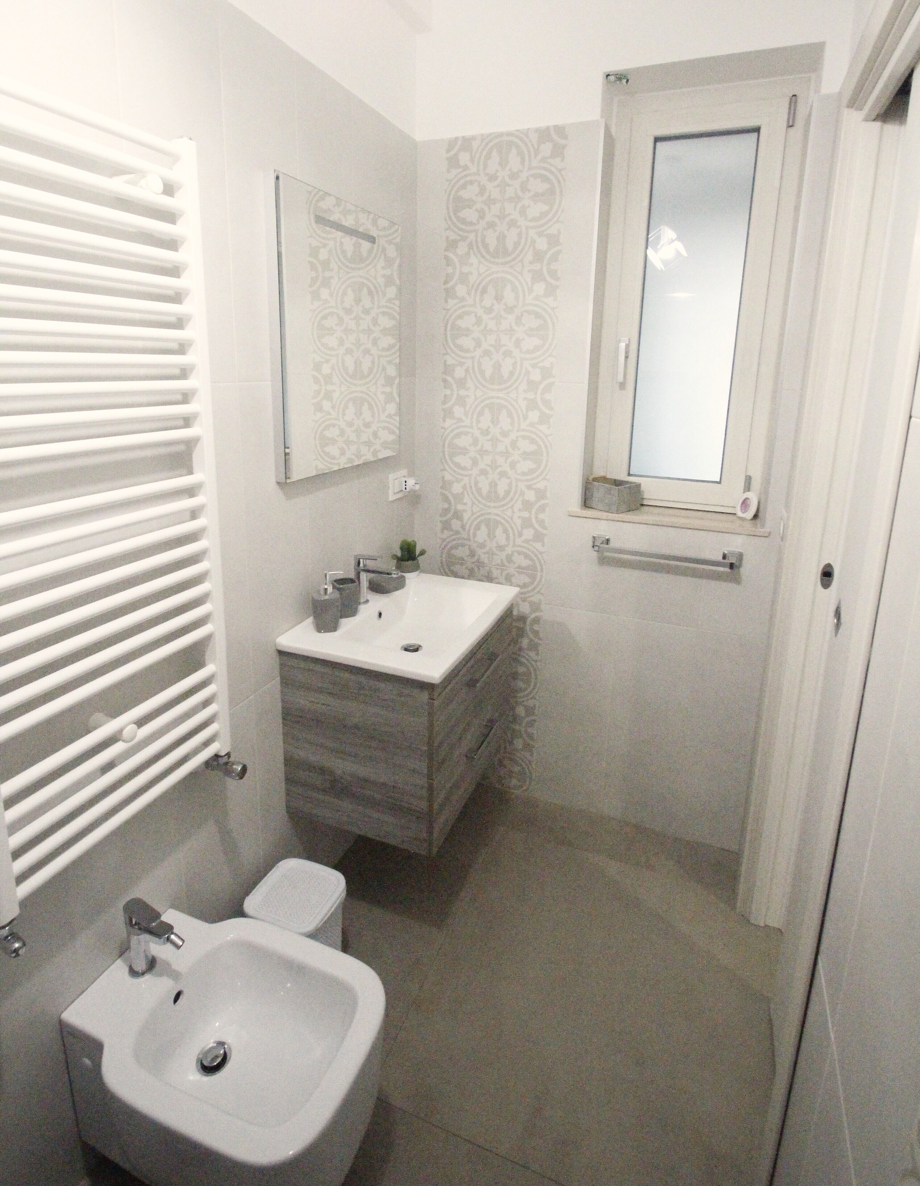 A bathroom with a white sink, mirror, and toilet.