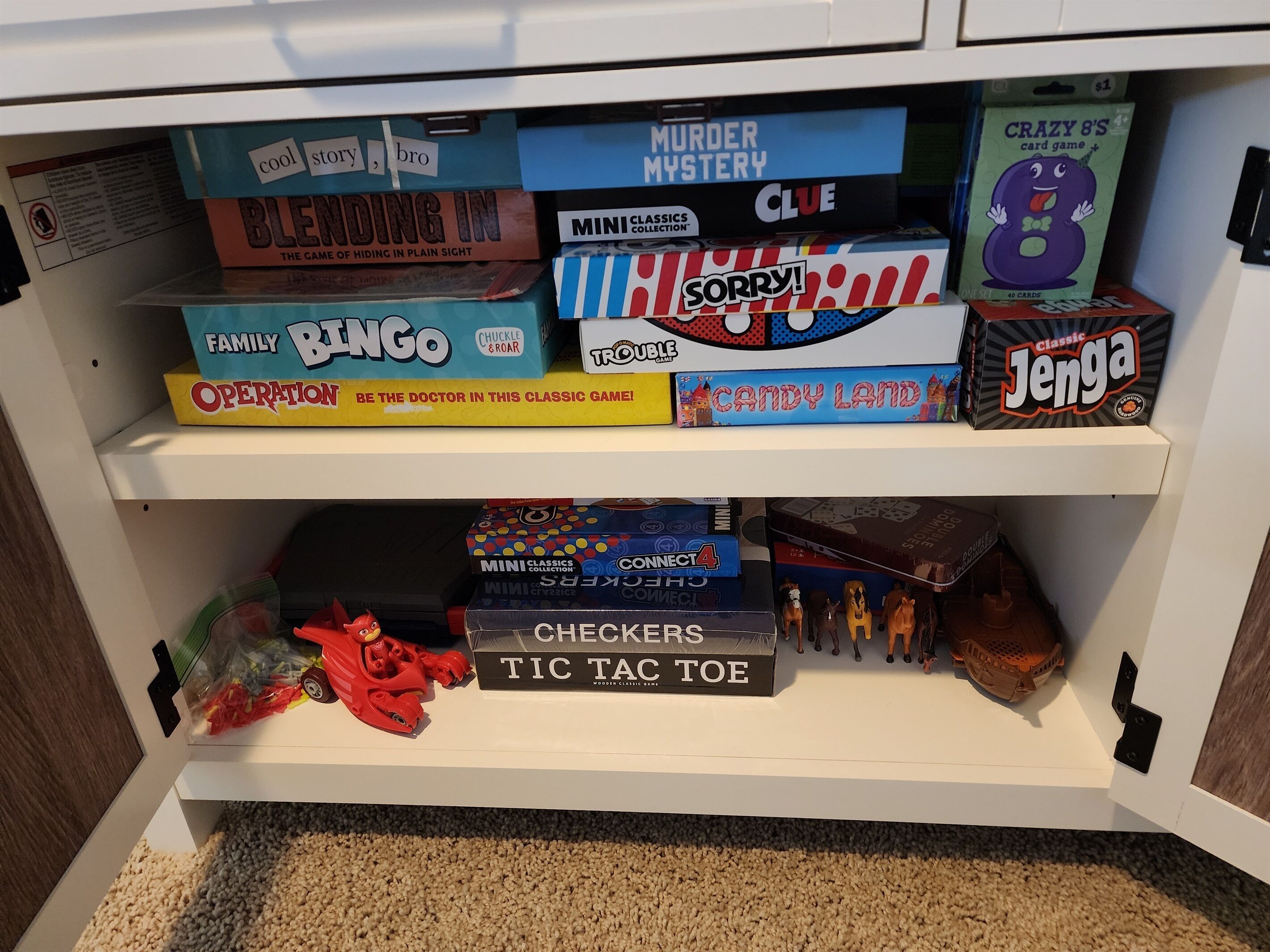 A shelf with various board games including 'Family Bingo', 'Candy Land', and 'Checkers'.