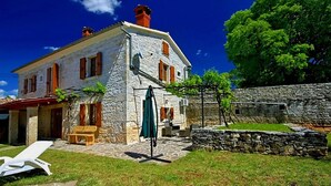 A stone house with a patio, outdoor furniture, and a stone wall. - Lovely home in Tinjan with WiFi (Tinjan)