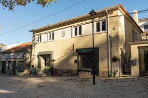 Stunning two-story building with a charming entrance, green awning, and metal gate.