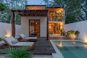 A modern house with a pool, wooden deck, and lounge chairs. - Modern and beautifully furnished 3-bedroom, 2-story villa: Suns Out Buns Out! (Tulum)