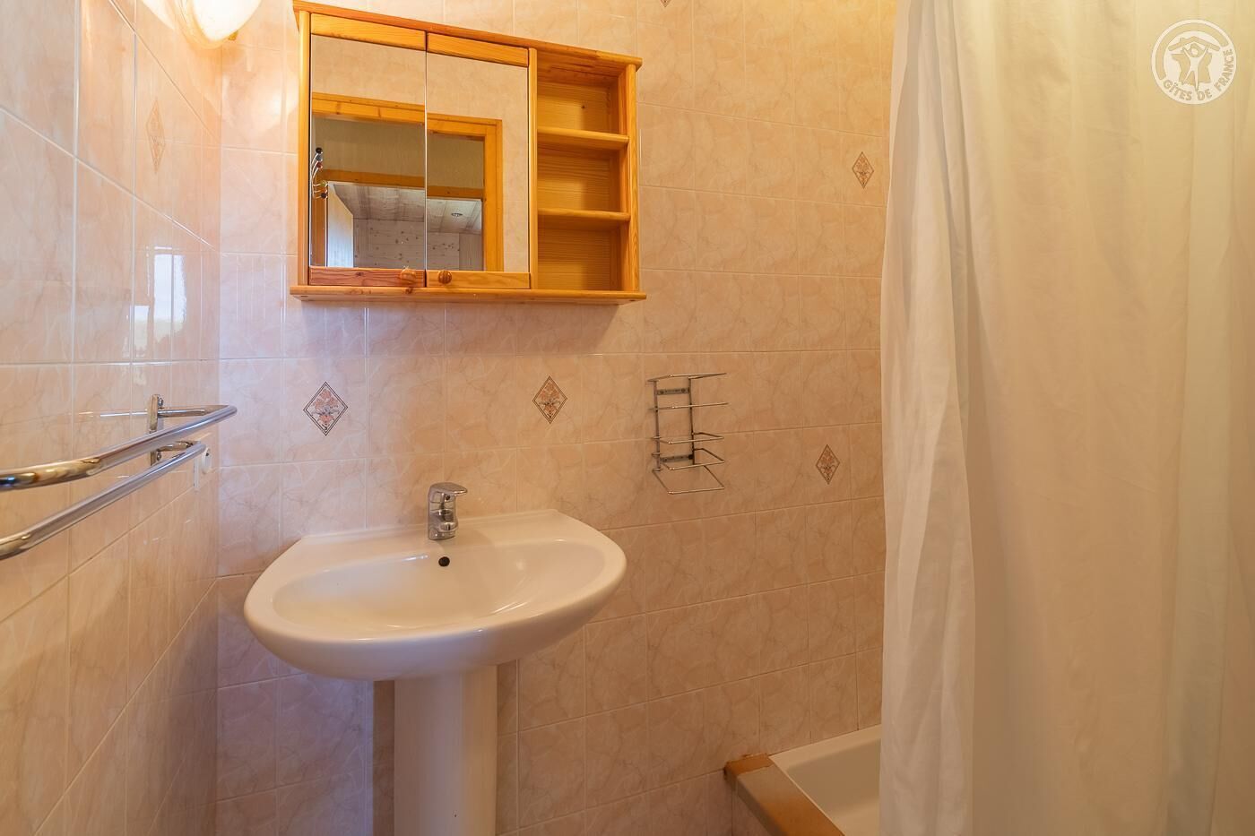 Ein Badezimmer mit Waschbecken, Spiegel und Duschvorhang.
