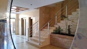A modern interior with a staircase, a brick wall, and a plant. - ACV - Torremar-2ª Linea Planta 7 Frontal 2 (OROPESA)