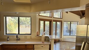 Eine moderne Küche mit Holzausstattung, einem Geschirrspüler von Bosch und einem Edelstahl-Kühlschrank.