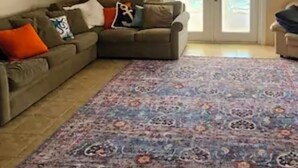 A living room with a sectional sofa, a patterned rug, a ceiling fan, and a sliding glass door leading to an outdoor area. - Beach House with Pool (Englewood)