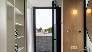 A modern bathroom with a large mirror, two sinks, and a built-in shelf unit. - AVASARALA by Buenavilla | A 3 bedroom luxury villa in Puerto Calero (Puerto Calero)