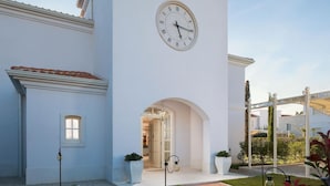 A building with a clock on the facade, a covered entrance, and a pathway leading to the main entrance. - Gorgeous home in Vabriga (Vabriga)