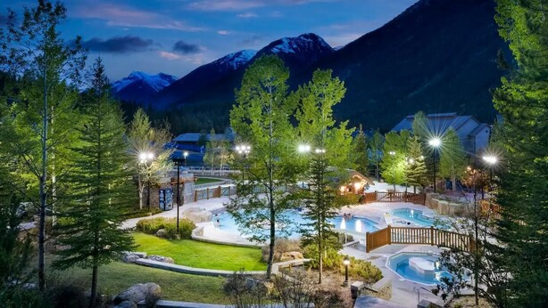 Un complexe hôtelier doté de plusieurs piscines, d’une pelouse bien entretenue et offrant une vue sur un paysage montagneux.