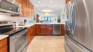 A modern kitchen with stainless steel appliances, wooden cabinets, and a central island.