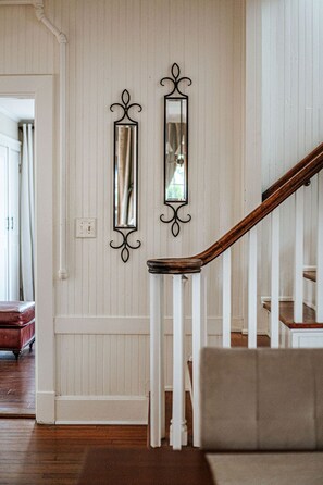 A staircase with a wooden handrail and white walls.