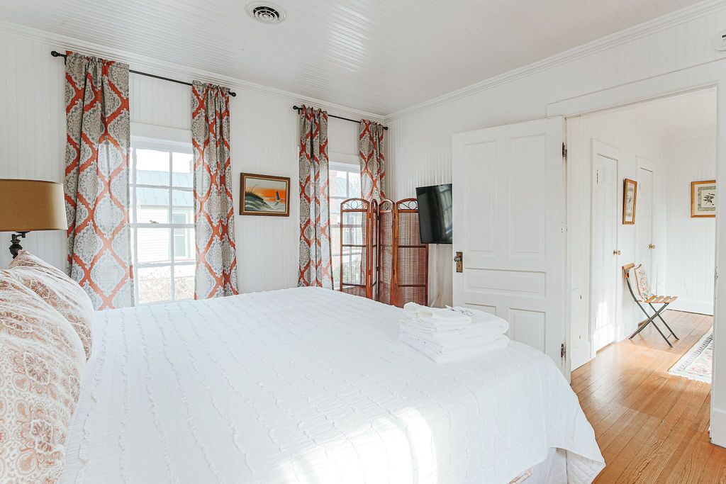 Ein Schlafzimmer mit einem großen Bett, einem Fernseher und einem Sessel.