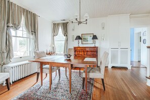 Ein Essbereich mit Holztisch, Stühlen und einem gemusterten Teppich.